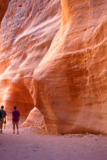 Il Siq, lo stretto canyon a fessura che funge da passaggio d'ingresso alla città nascosta di Petra, Giordania