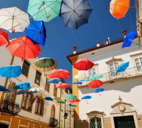 Évora, una tipica piazza della città ricoperta da ombrelli colorati fluttuanti