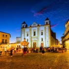 Piazza Girardo (Praça do Giraldo), in risalto la fontana centrale realizzata in marmo con otto cannelle rappresentanti le principali vie di Évora, subito dietro la Chiesa di Santo Antão costruita nel 1557 da re Henrique