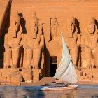 Spettacolare scenografia della facciata del Tempio di Abu Simbel vista da un imbarcazione a vela in navigazione sul fiume Nilo